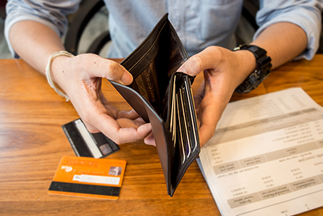 A man looks at his credit cards and applies for a personal loan to consolidate his debt.