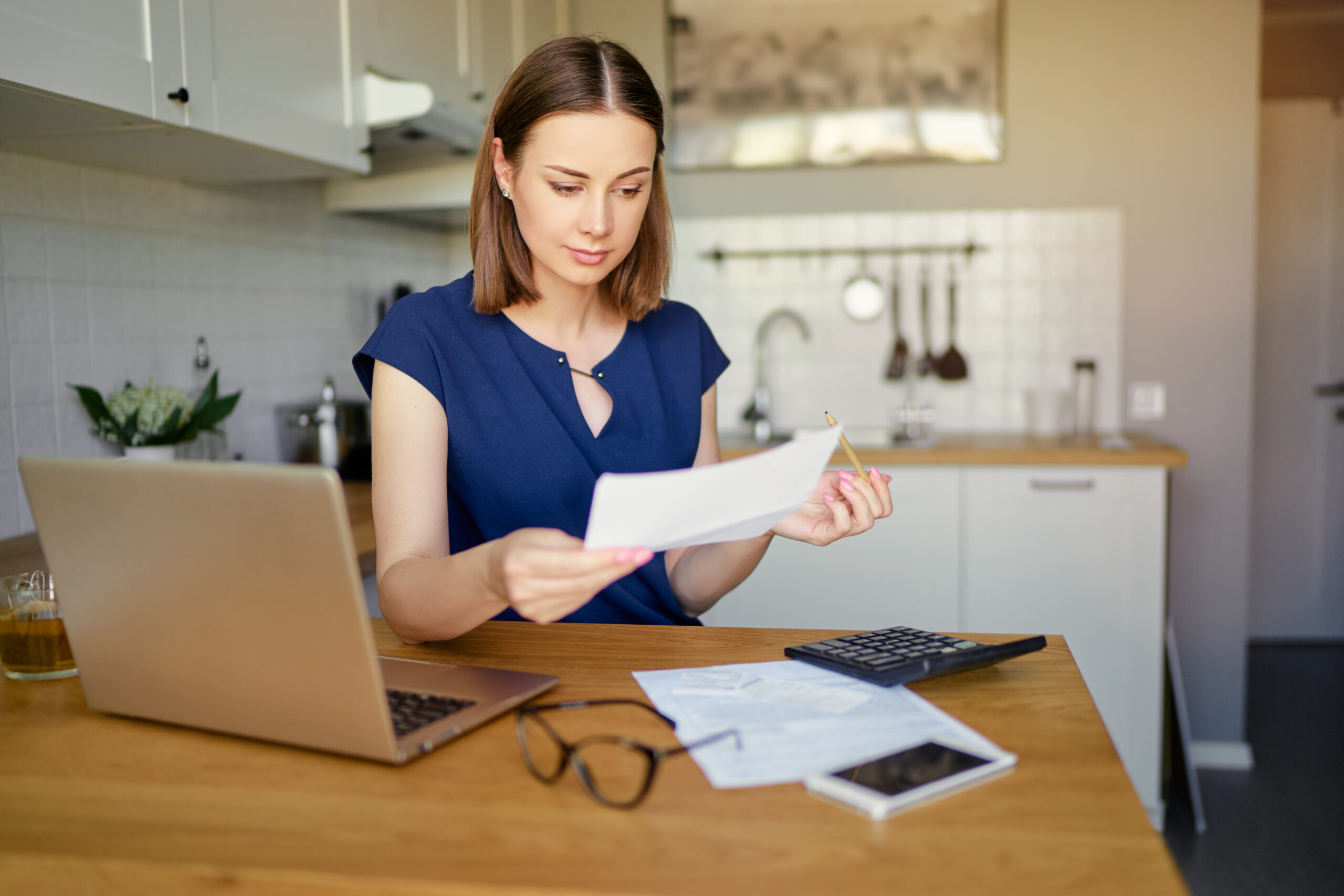 A young woman reviews a bank statement and wonders if a personal loan vs. a credit card is better for her financial situation.