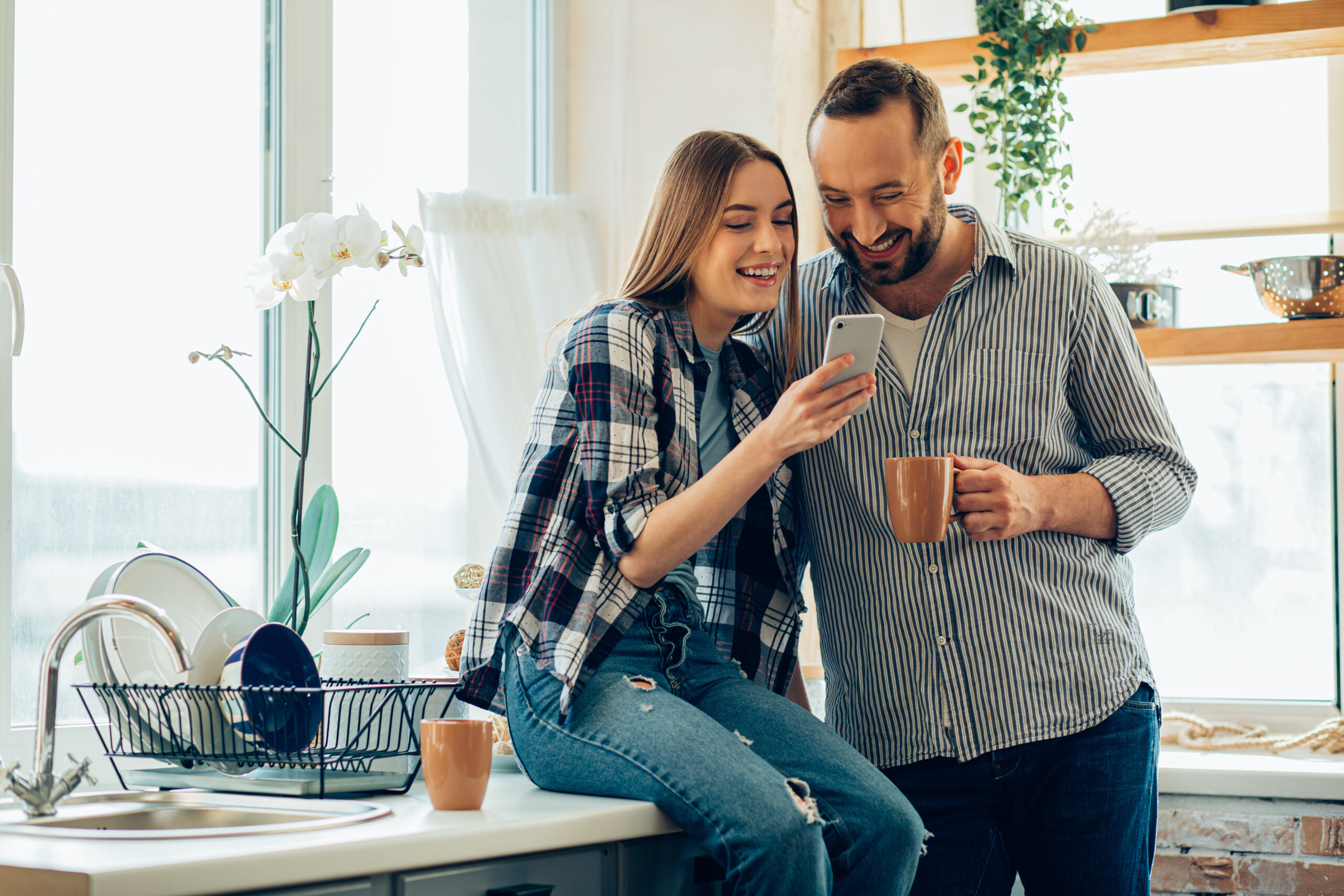 A smiling couple discusses how to use a HELOC while standing the kitchen of their home.