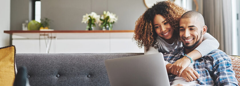 Happy young couple looks at financial resources from their credit union.