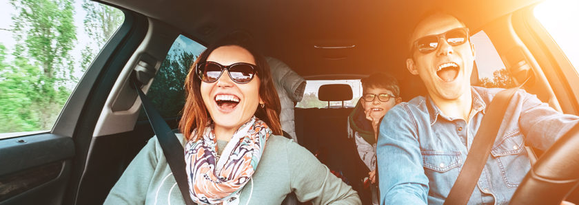 Smiling family in car on sunny day