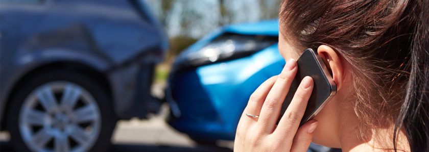 Young giel on phone with car fender bender in background