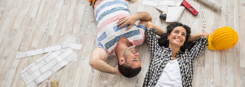 Couple laying on floor during home remodel project