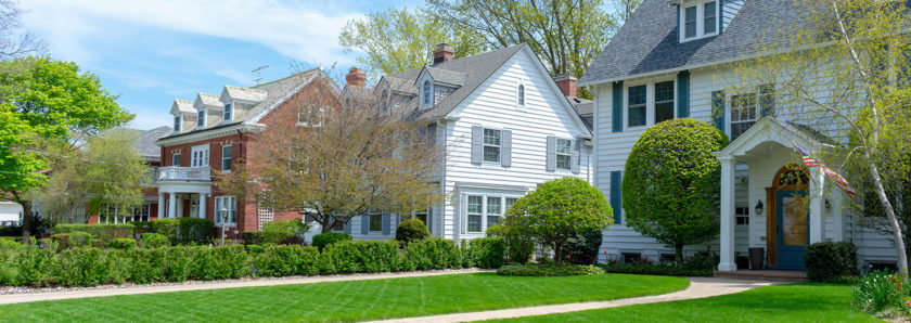 Street view of houses on sunny day with green grass
