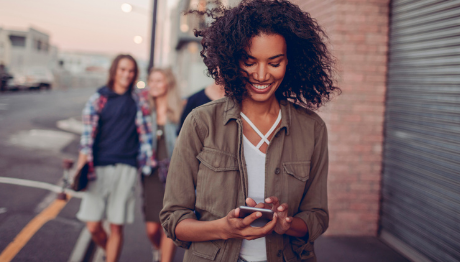 ICU Day Contest Referral Entry - Young female walking down street looking at phone