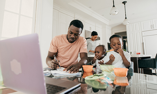 Father with kids at table in kitchen reviewing papers