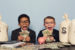 Two young boys dressed as businessmen counting cash with excitement