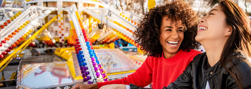 Two young females laughing while on a carnival ride