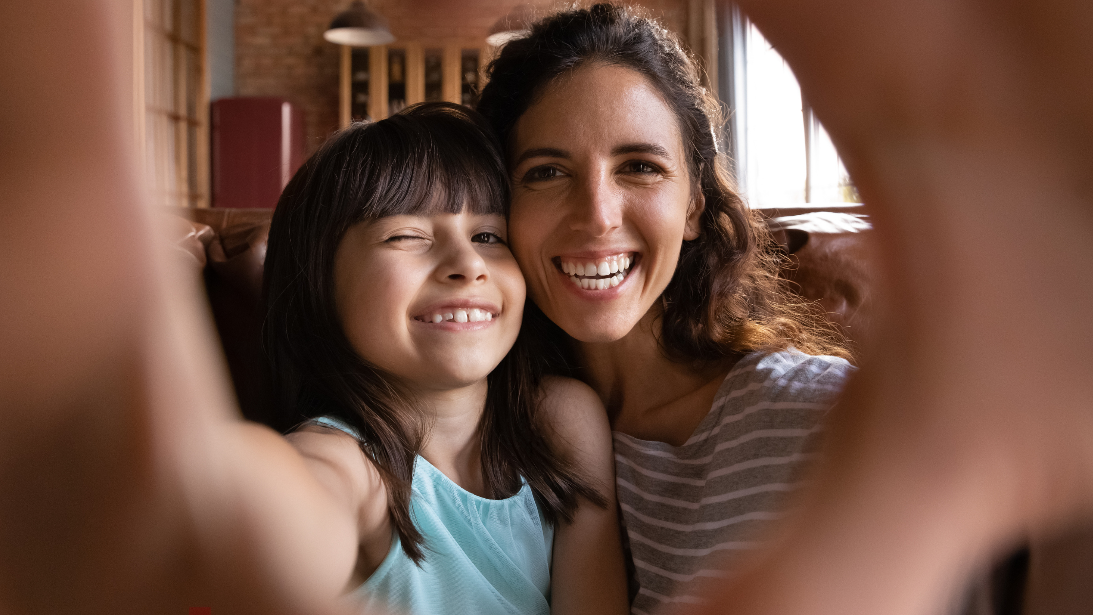 Mother and daughter laughing with outstretched hands