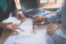 Hands pointing at charts on desk of finances