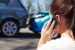 Girl on phone with vehicle accident in background