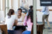 Female banker sitting at desk talking with two female clients