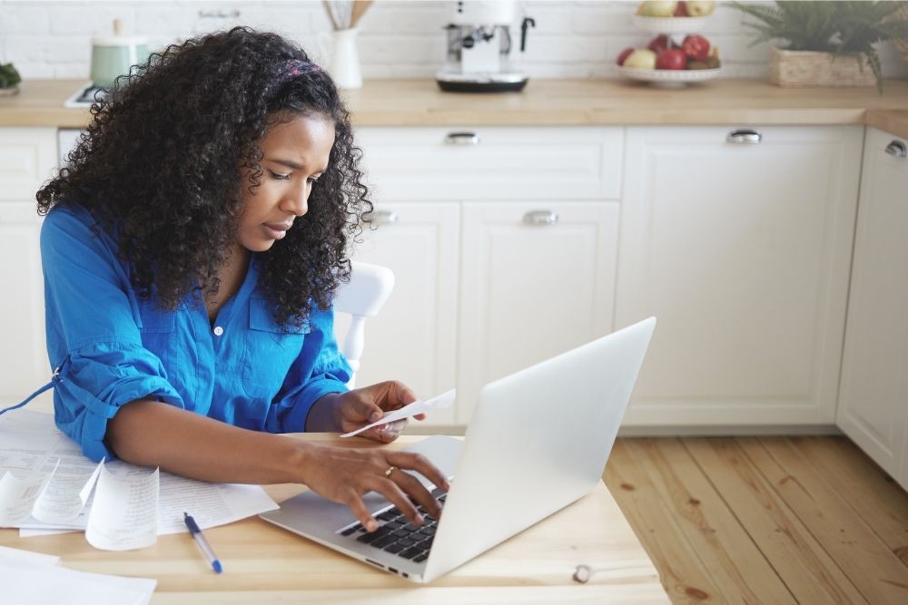 a young woman diligently monitors her checking account with online banking