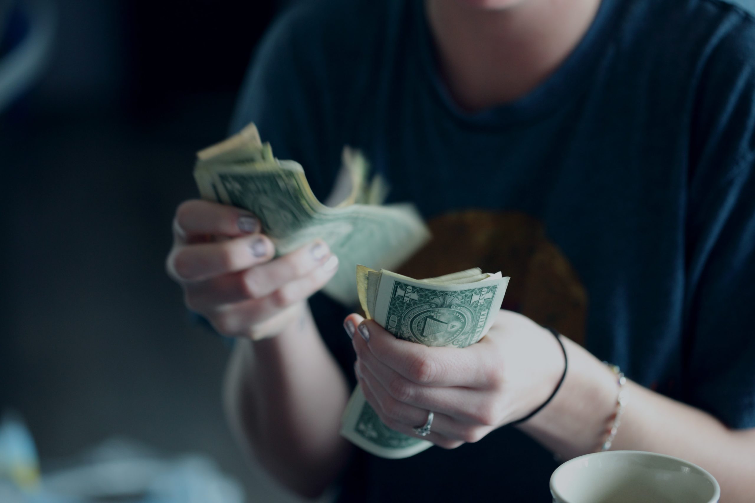 Womans hands counting dollar bills